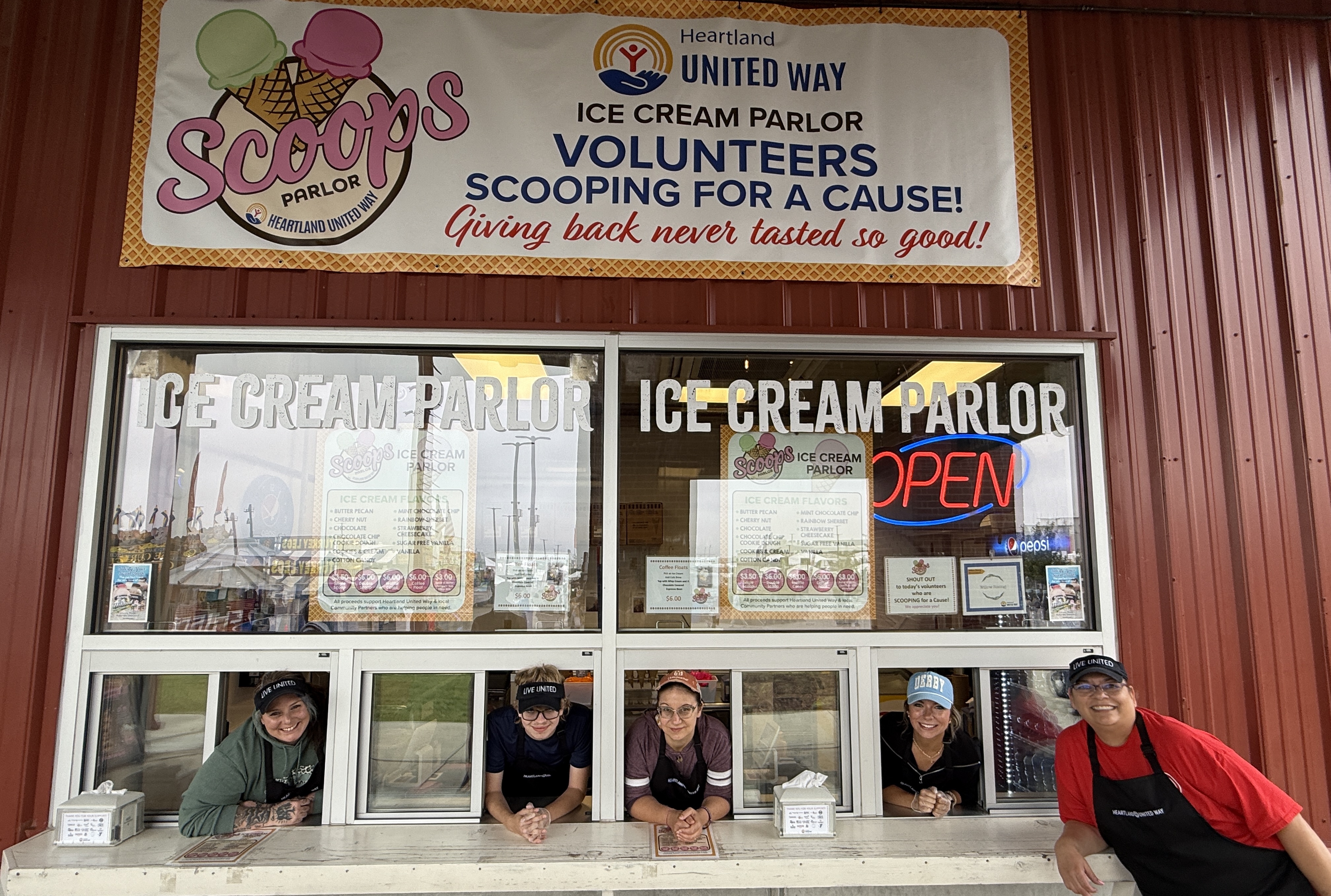 Volunteers peak out of windows at the Scoops Ice Cream Parlor during the 2025 Nebraska State Fair.