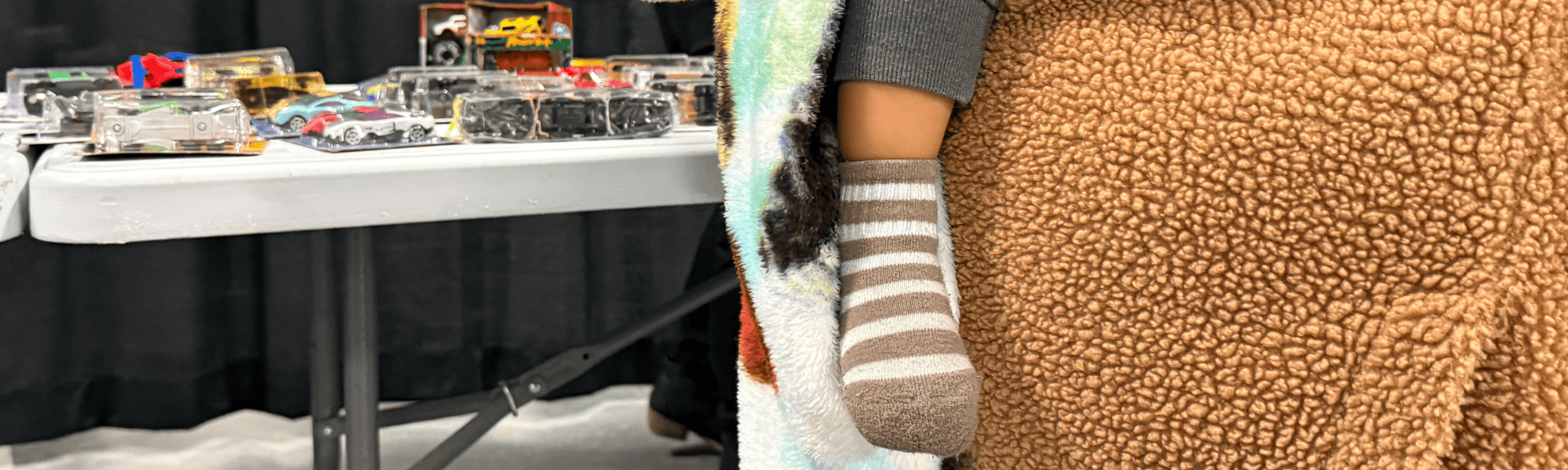 A parent holds a child at the 2025 Heartland United Way & Toys for Tots Distribution.