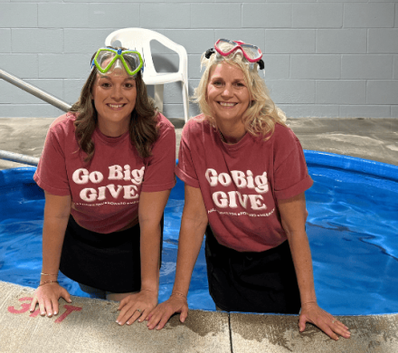 Greater Grand Island Community Foundation CEO Melissa DeLaet and Heartland United Way President Karen Rathke stand in a hot tub to promote Go Big GIVE.