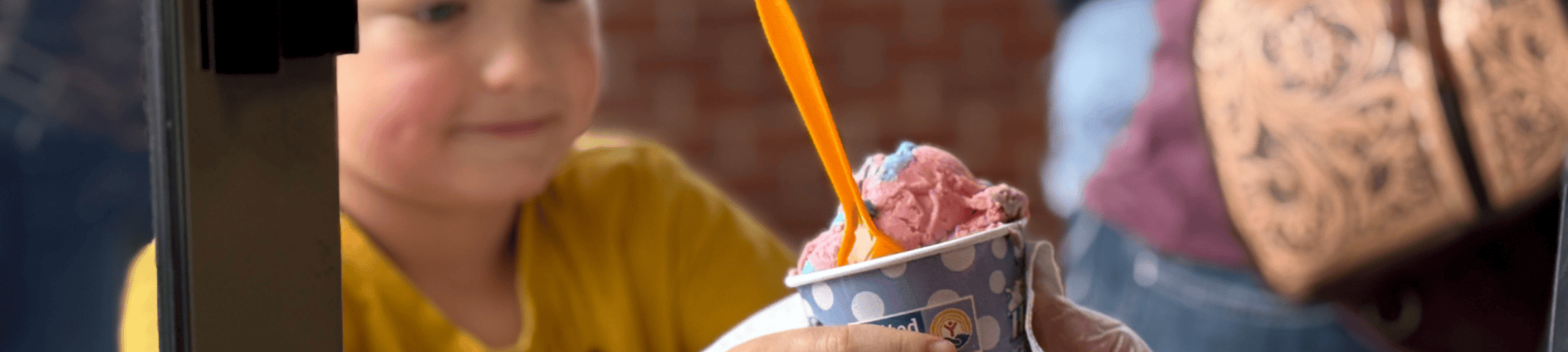 Elijah Wachter, of Ravenna, receives Scoops ice cream during the 2025 Nebraska State Fair.