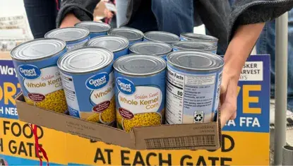 An FFA member places cans of food on a scale during Husker Harvest Days 2025.