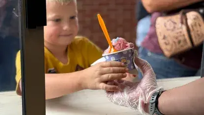 Elijah Wachter, of Ravenna, receives Scoops ice cream during the 2025 Nebraska State Fair.
