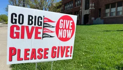 A Go Big GIVE sign stands outside a Central City school in 2025.